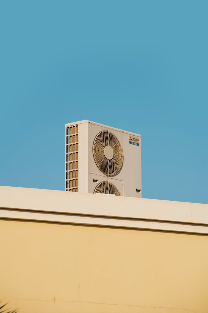 services-img A simple and modern air conditioner unit on a rooftop with a blue sky backdrop in Dubai.