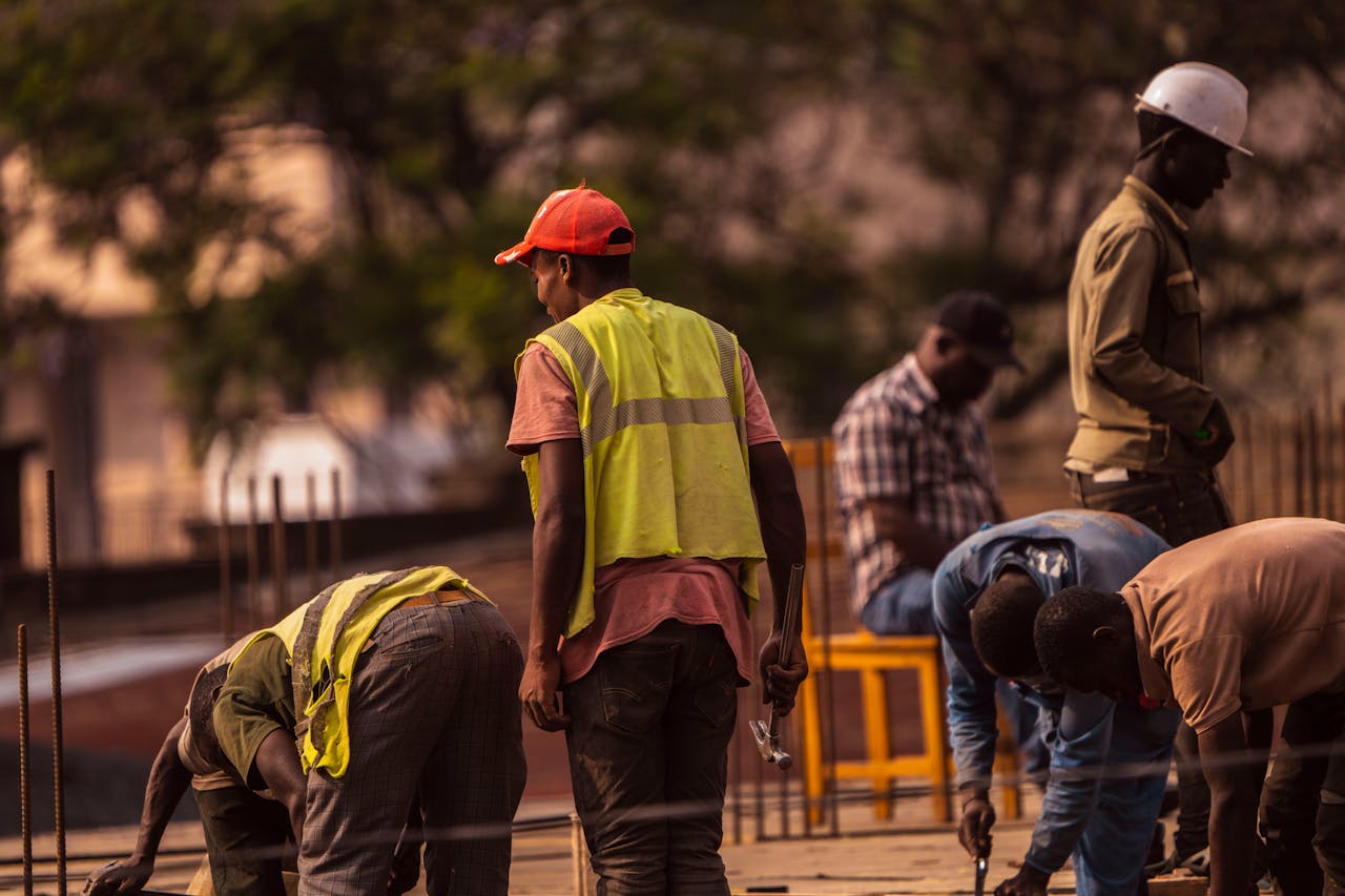 services-03 Group of male construction workers on site wearing safety gear during daytime.