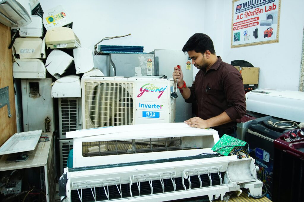 pexels photo 33671149 33671149 Technician repairing an air conditioner unit in New Delhi workshop.